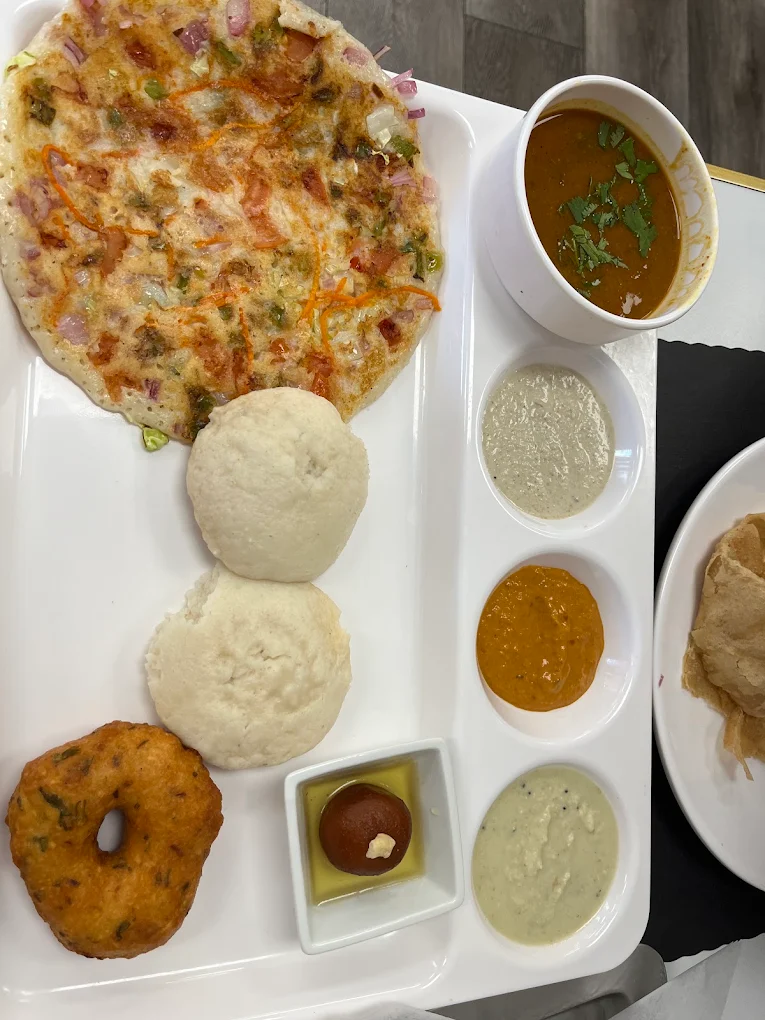 South Indian Idli Combo with steamed idlis, medu vada, uttapam, chutneys and gulab jamun