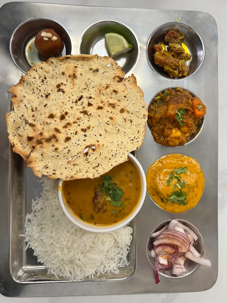 Authentic Gujarati Thali with roasted papad, rice, dal, subji and gulab jamun