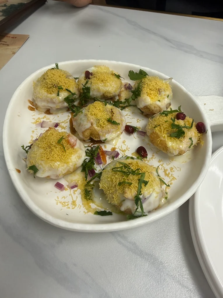 Dahi Puri chaat with spiced potato filling, chilled sweet yogurt, sev and pomegranate