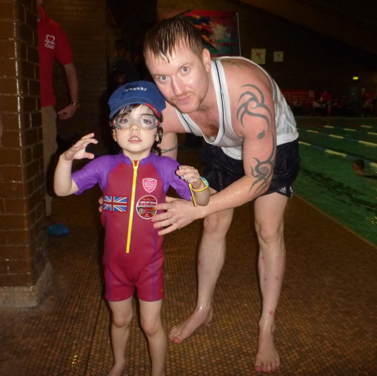 Benjamin Hamlett providing poolside guidance to a young swimmer during a swimming lesson