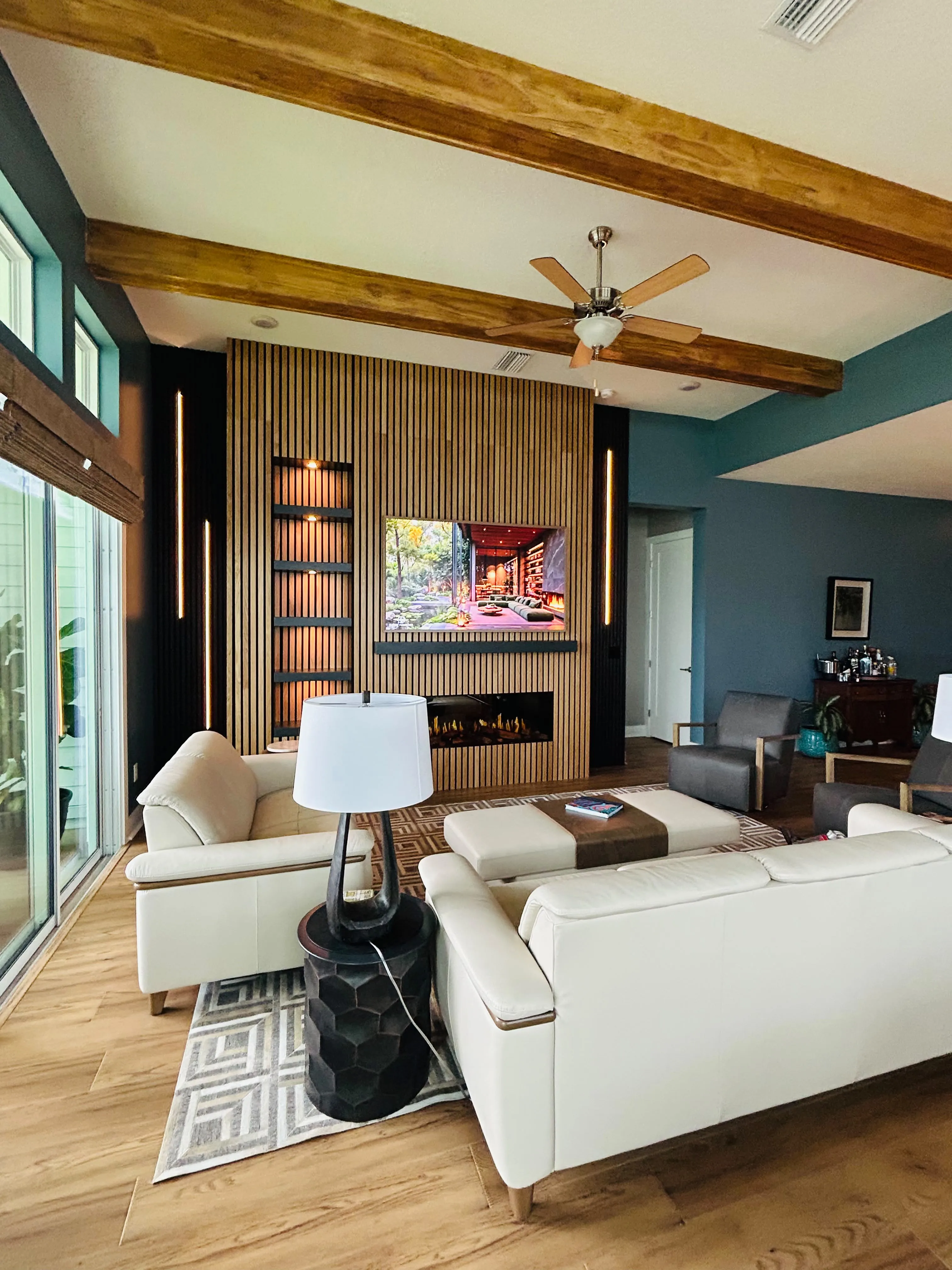 Custom wood slat feature wall with TV mount, shelving, and electric fireplace by JS Remodeling & Handyman