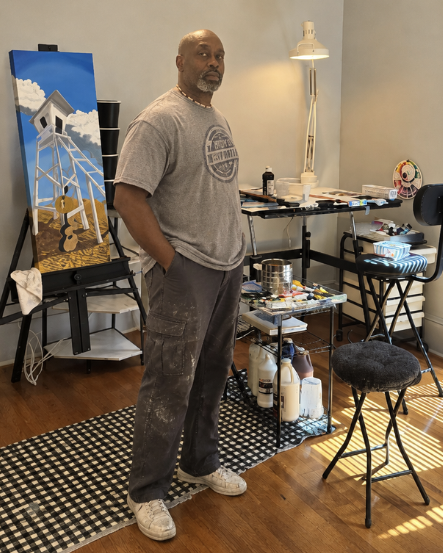 Richard Franklin standing in his studio beside an easel with his artwork