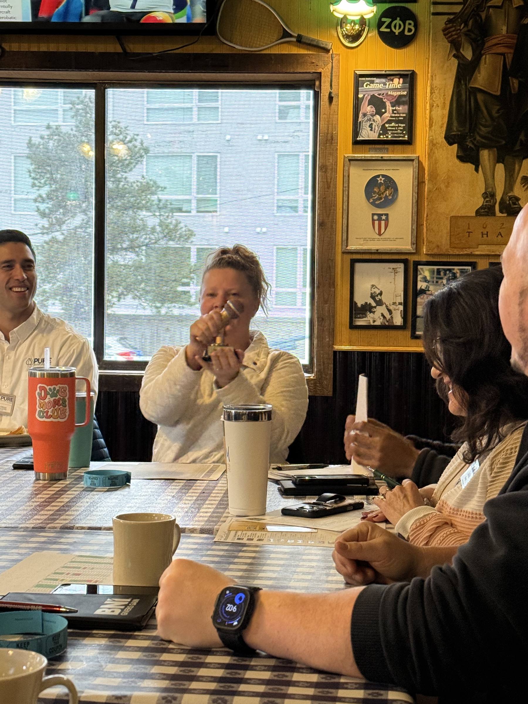 Chapter table applauding and cheering during a meeting presentation