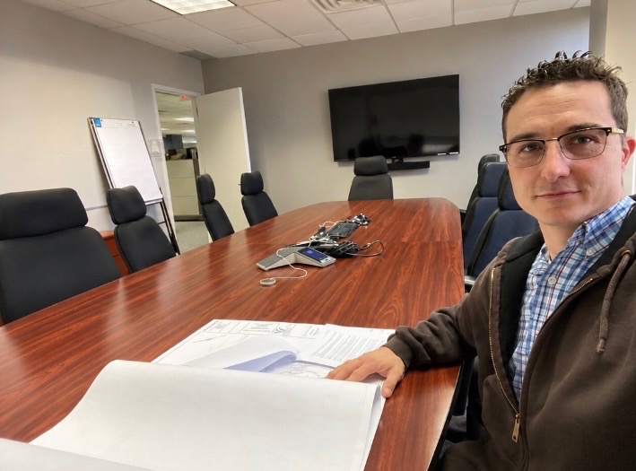 John W. Callahan reviewing architectural plans at conference table