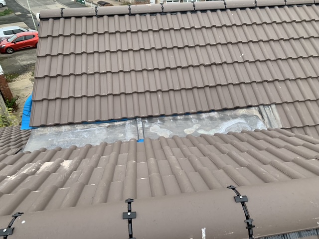 Lead flashing dressed between roof slopes to create a lasting, weatherproof seal.