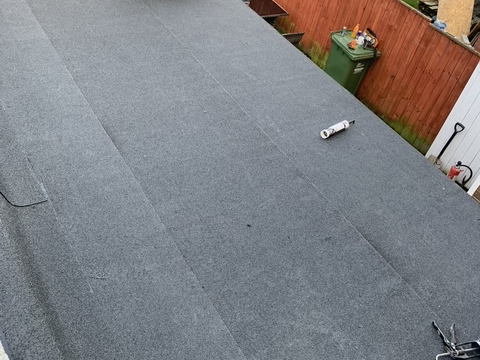 A new flat roof covering laid with neat edges and a watertight finish.