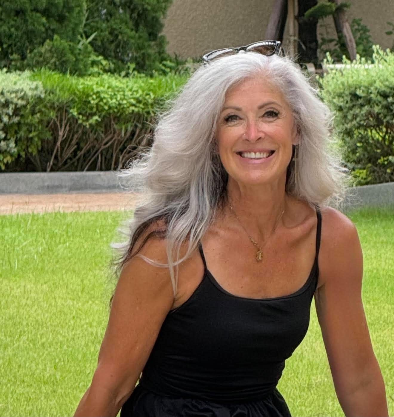 Becki smiling warmly outdoors, vibrant and living activated