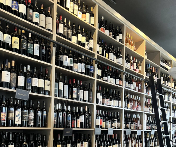 The Stowaway Wine Bar floor-to-ceiling curated wine wall library with ladder
