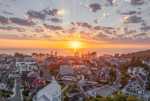 Aerial golden hour sunset over Seabrook, Washington coastline and town center
