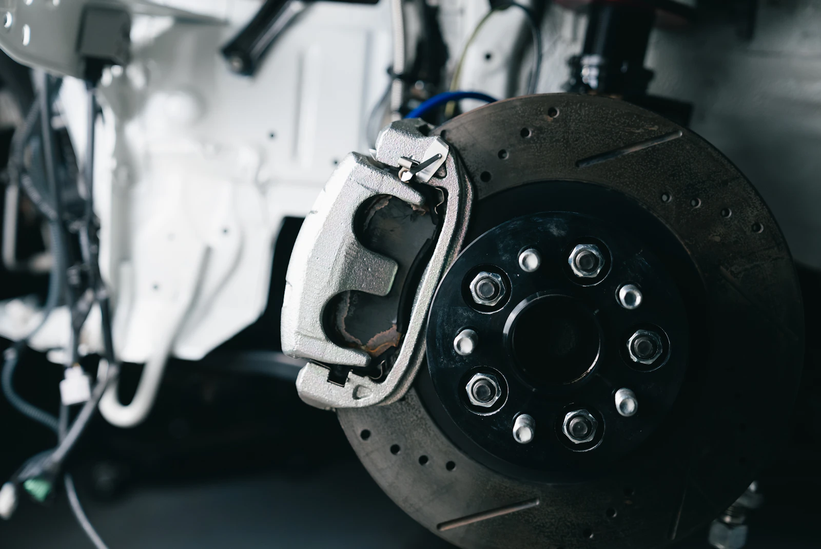 Brake rotor and caliper behind a car wheel