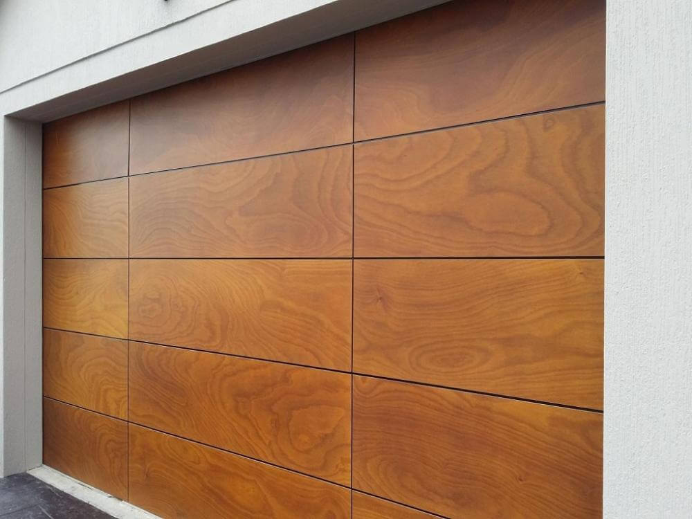 Timber look sectional garage door with paneled design and hardwood finish