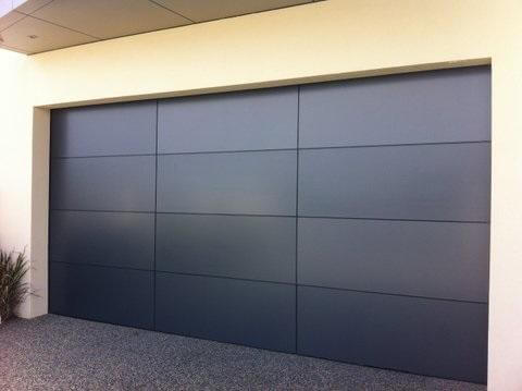 Alucobond folded edge garage door with panel design and aluminium finish.