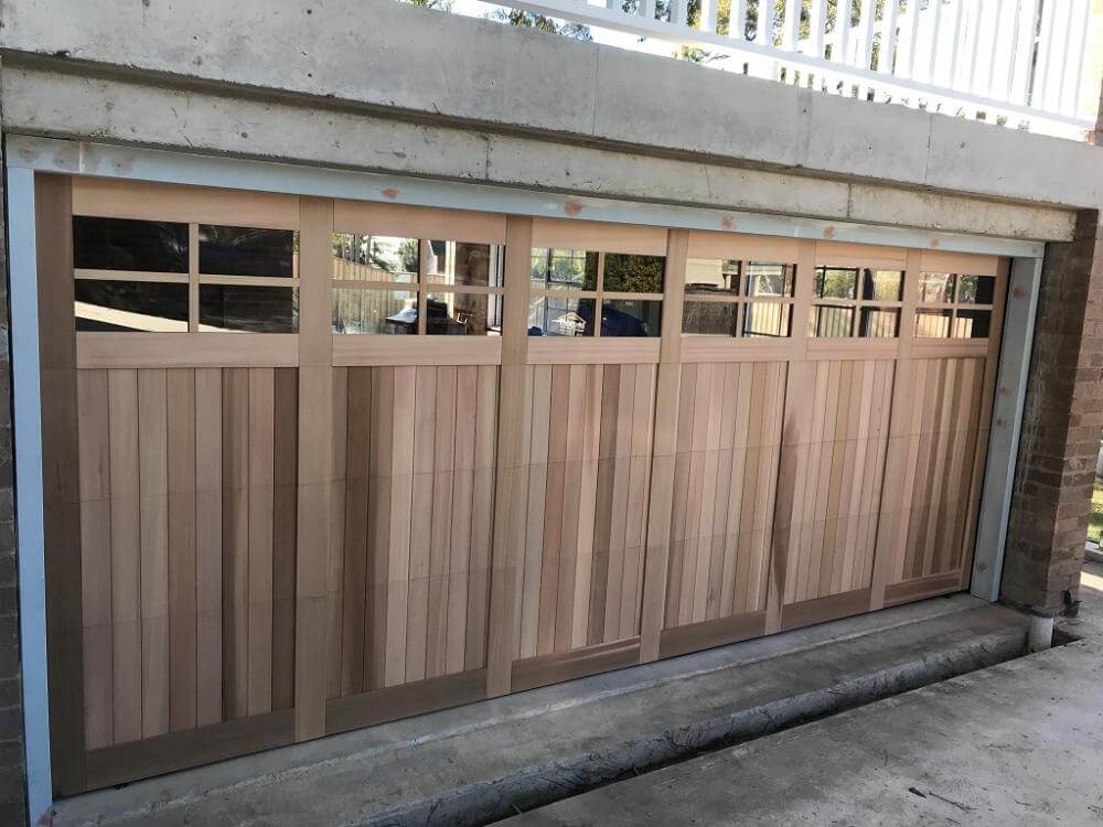 Carriage panel garage door with highlight windows and timber design.