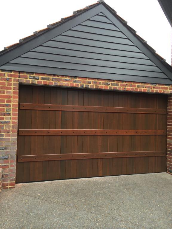 Timber panel garage door design with overlayed boards and timber batten details.