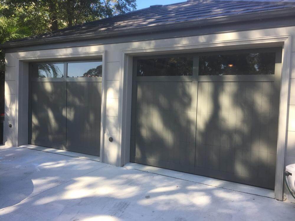 Carriage panel garage door with windows and timber look design.