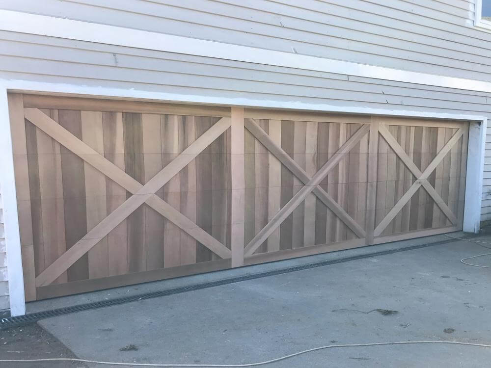 Vertical timber garage door with overlayed boards and cross panel detailing.