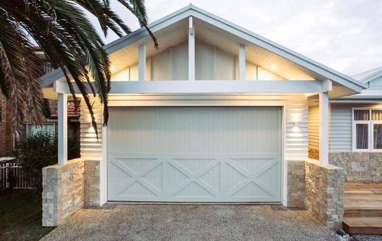 Vertical lined cedar garage door with overlayed boards and timber raised panel design.