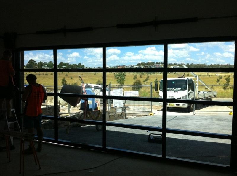 Glasslite garage door installation with window highlights and view of surrounding landscape.