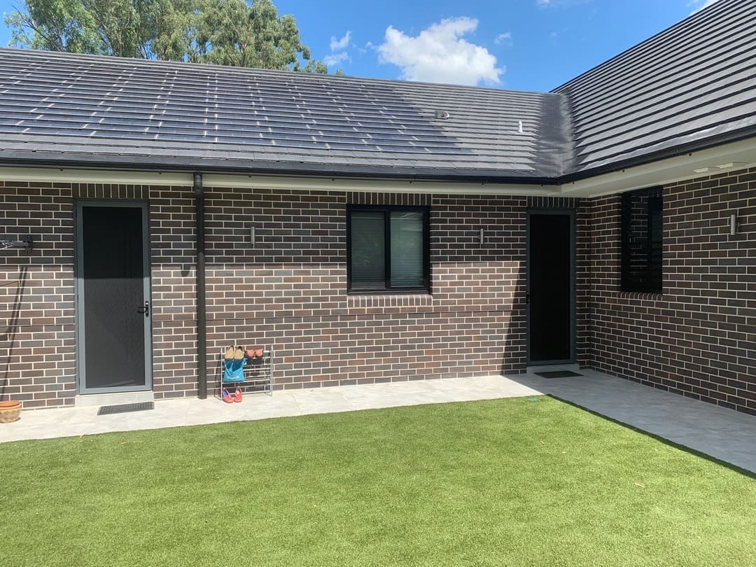 Charcoal security screen doors and window screens fitted to brick residential exterior
