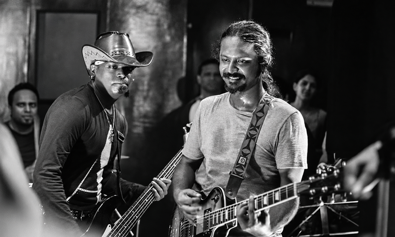 Black and white performance shot of The Blue Mister smiling with fellow musician