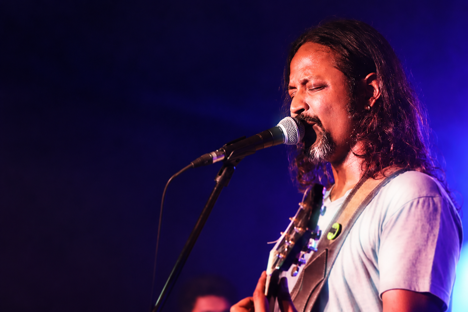 The Blue Mister performing live under moody blue stage light