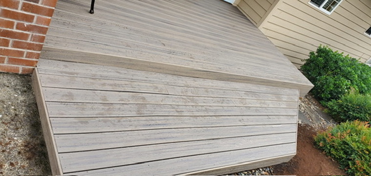Fresh modern gray composite deck boards neatly installed on angled front step