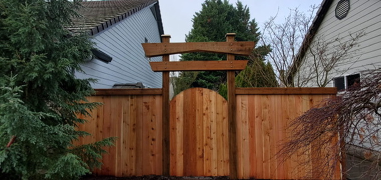 Custom cedar fence with decorative Japanese Torii arbor and arched wooden gate