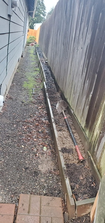 Side yard excavation and wooden form trenching prep for retaining wall and walkway