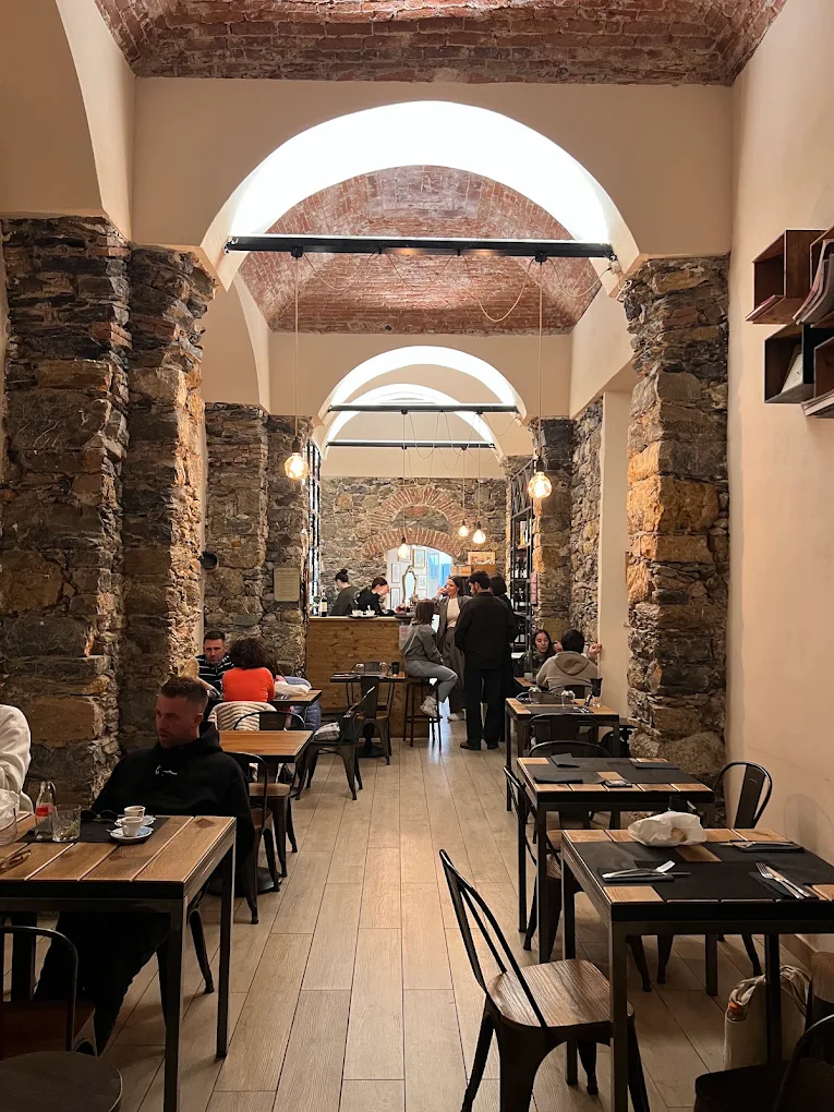 Interno di Fara Bistrot con archi in mattoni e pareti in pietra a vista