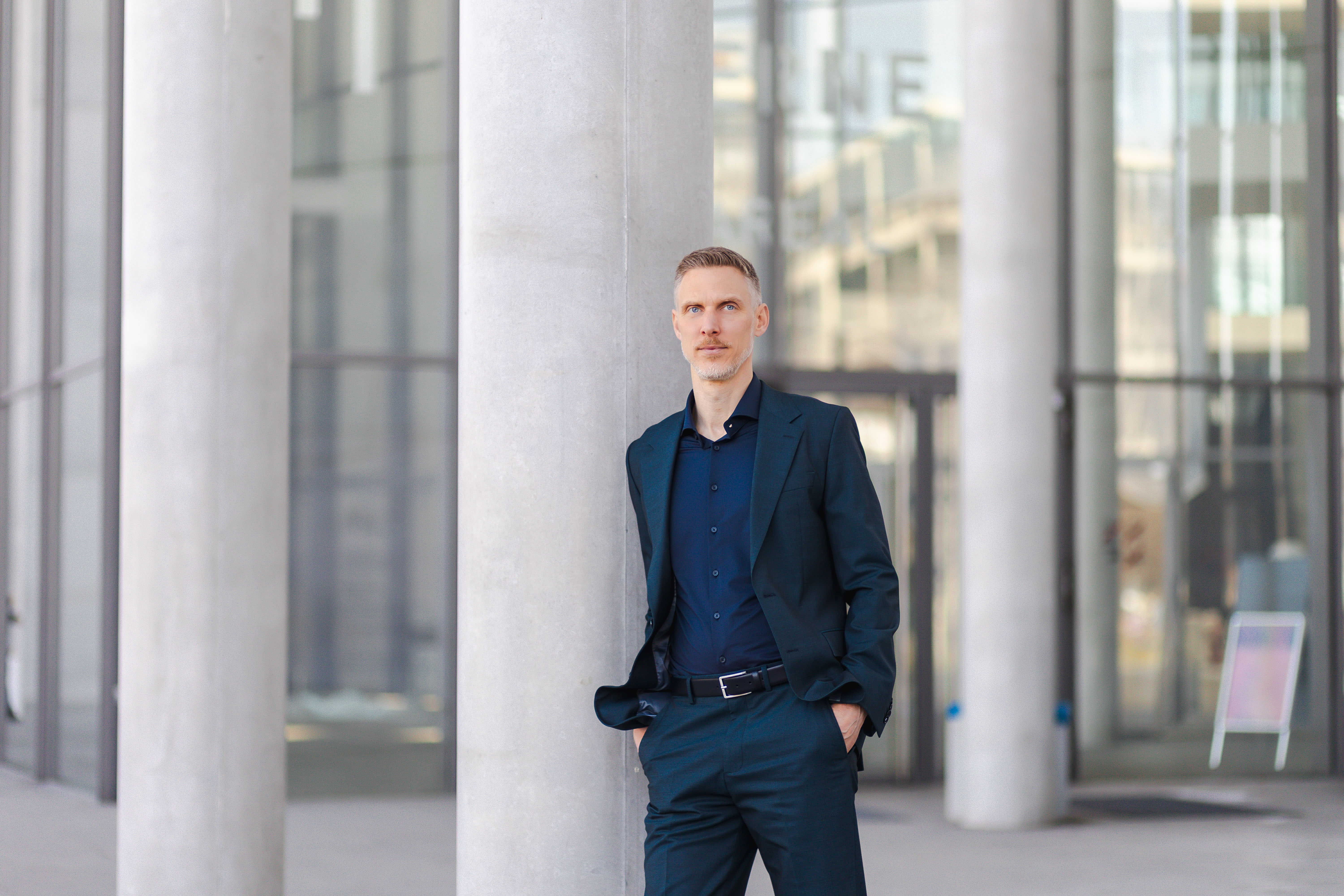René Sahm im Anzug vor moderner Architektur