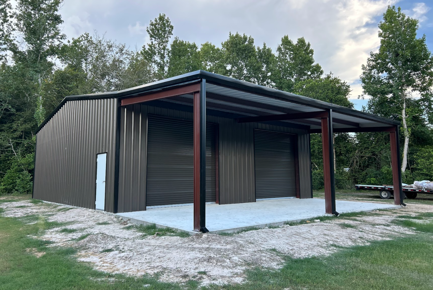 Charcoal steel workshop with dual roll-up doors and front porch canopy