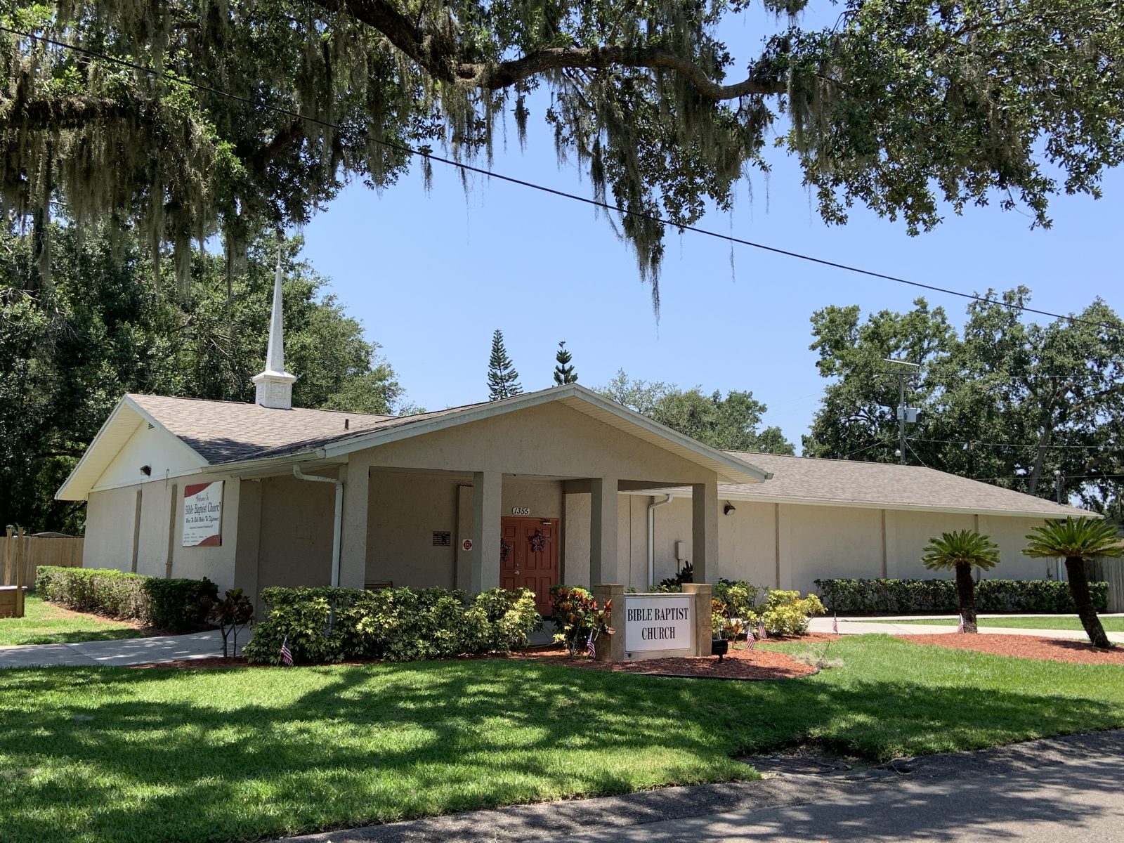 Exterior of Bible Baptist Church beneath oak trees in Bartow, Florida