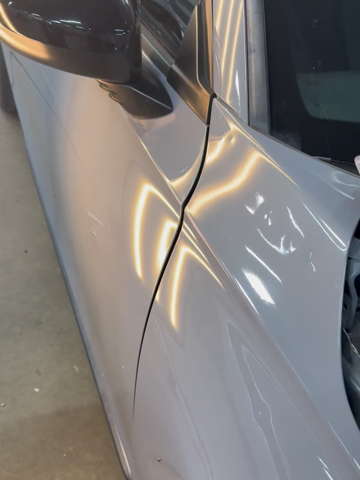 Dent distortion revealed through PDR reflection lighting along a vehicle panel edge