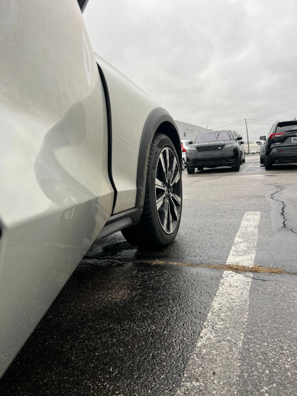 Visible dent damage on a white vehicle panel
