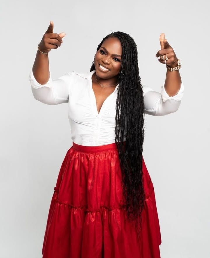 Vibrant personal branding portrait of woman in crisp white shirt and red skirt smiling with double finger guns