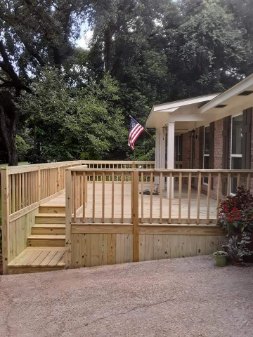 Elevated custom wood deck with integrated stairs and solid skirt framing
