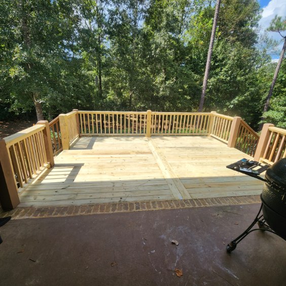 Spacious custom wood deck with precision balusters and forest views by Protech Decks