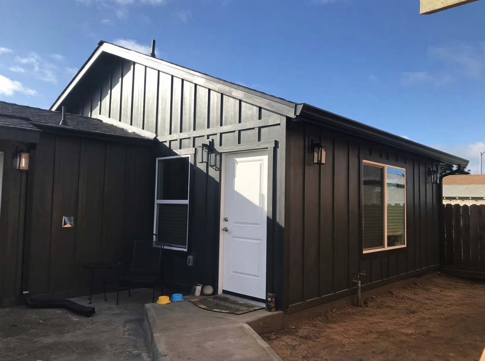 After — completed modern dark board-and-batten exterior addition with new door and trim, San Leandro CA