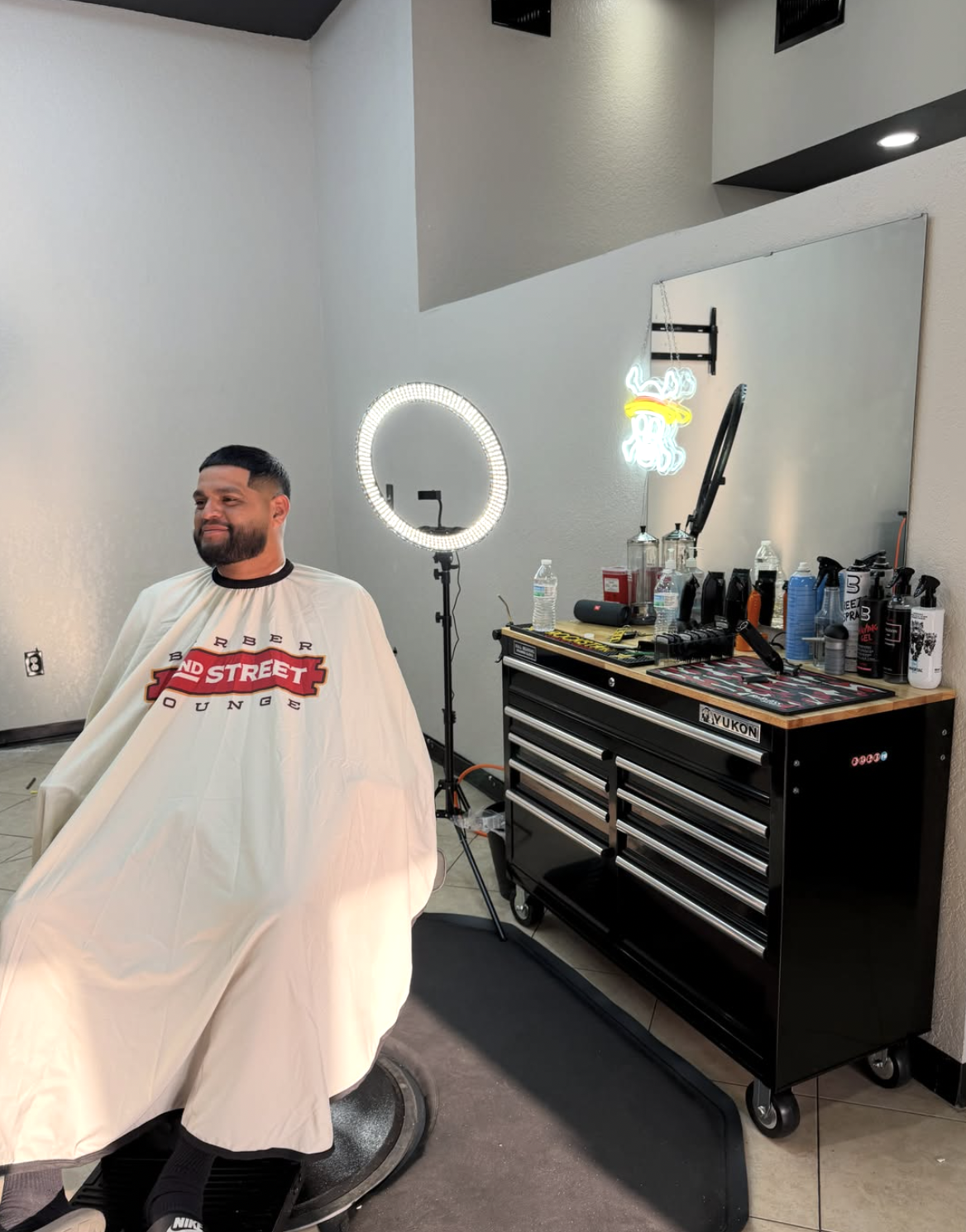 Client in chair with custom 22nd Street Barber Lounge cape