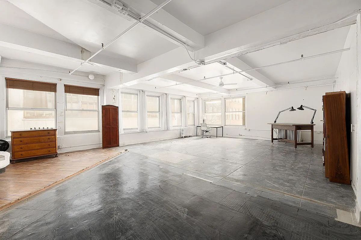 Historic artist studio volume of Juan Downey with expansive open concrete floor and continuous window line