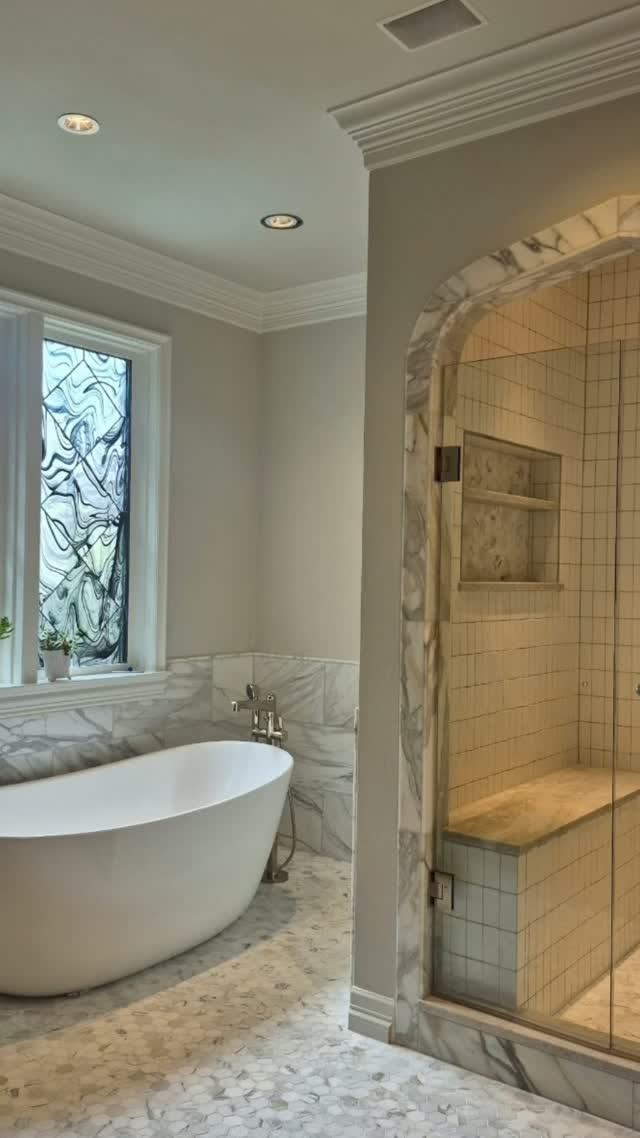 Luxury bathroom with floor-to-ceiling shower tile, a built-in niche, and a clean modern finish