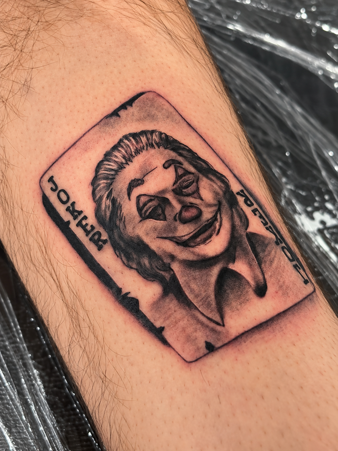 Black and gray portrait tattoo designed inside a playing card