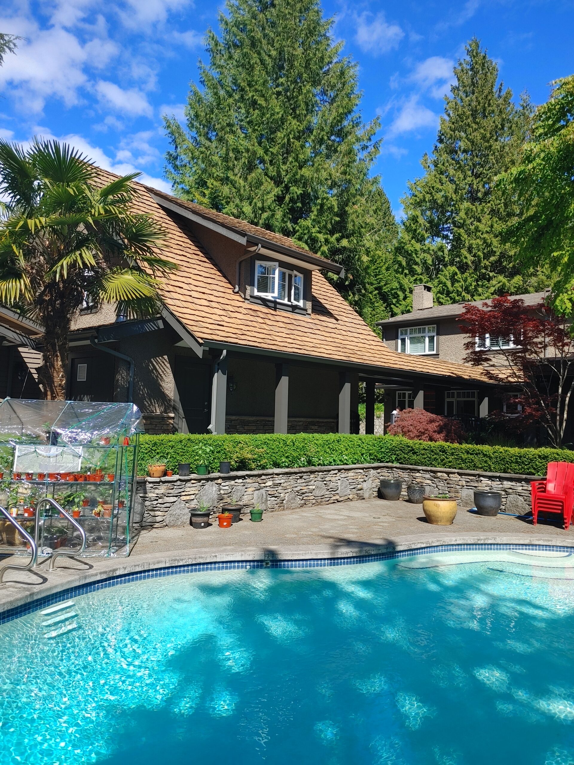 Full residential home with a cedar shake roof and backyard swimming pool