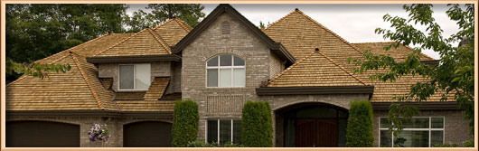 Wide exterior view of a home featuring a cedar shake roof