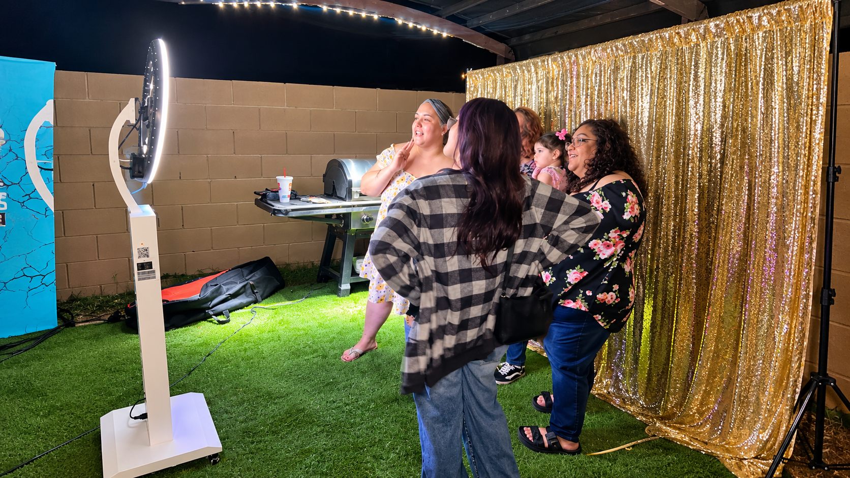 Guests enjoying the digital photo booth with gold sequin backdrop