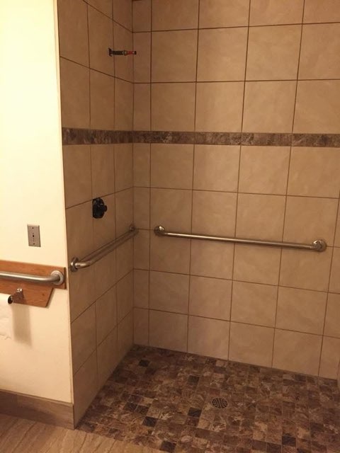 Tiled walk in shower with mosaic floor installed by American Flooring LLC