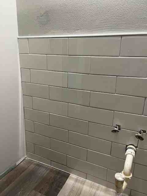 Subway tile wall installed in a laundry area by American Flooring LLC