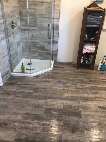 Wood look bathroom floor installed by American Flooring LLC
