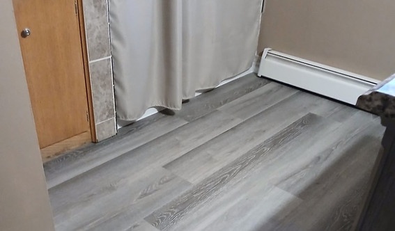Gray luxury vinyl plank floor installed in a bathroom by American Flooring LLC