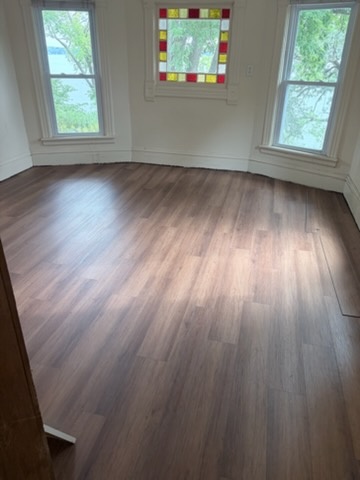 Dark plank floor in a bay window room installed by American Flooring LLC